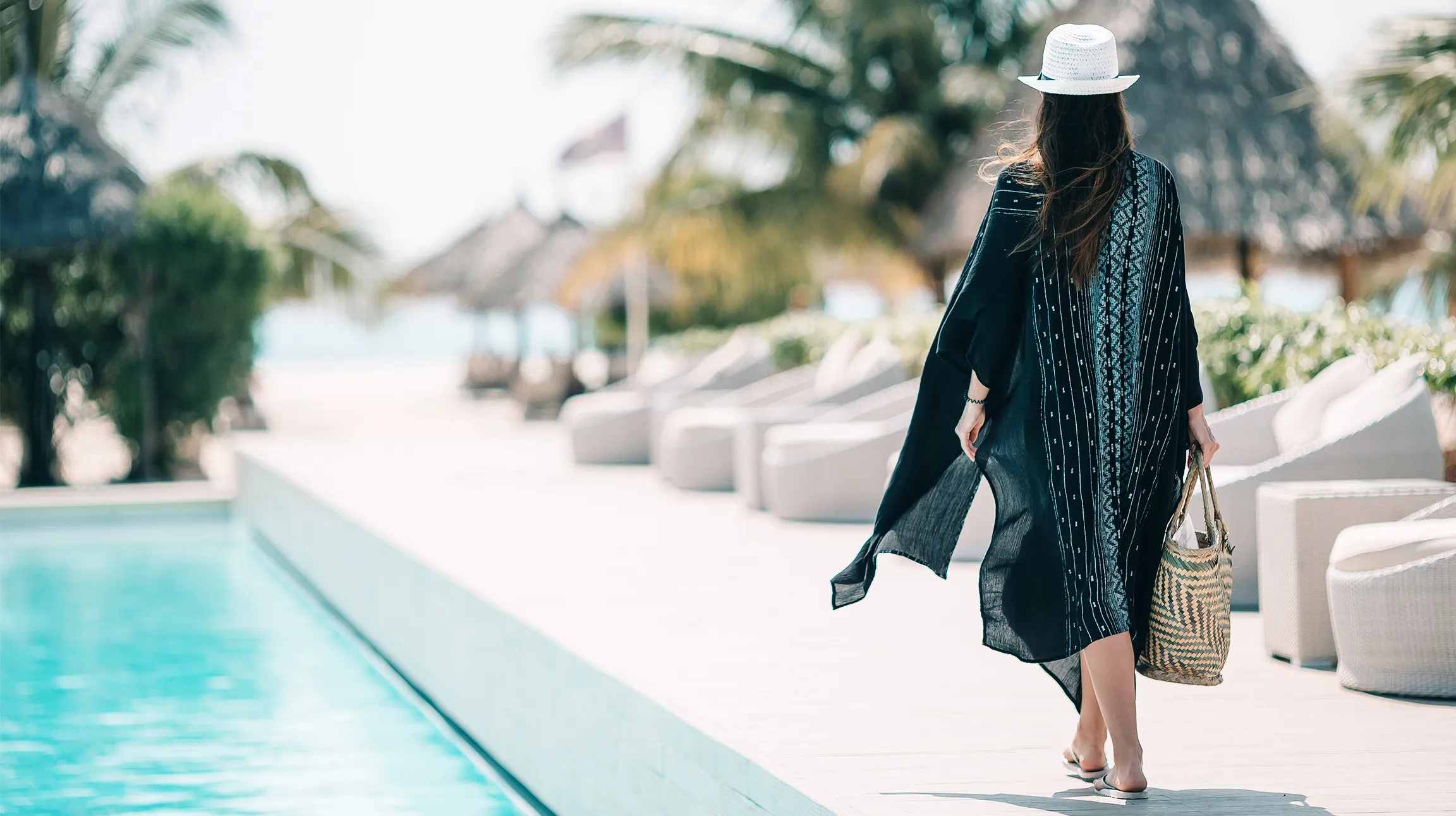 A guest walking the poolside path of a boutique resort.